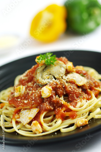 Spaghetti ramen noodle pasta with tomatoes sauce on black dish