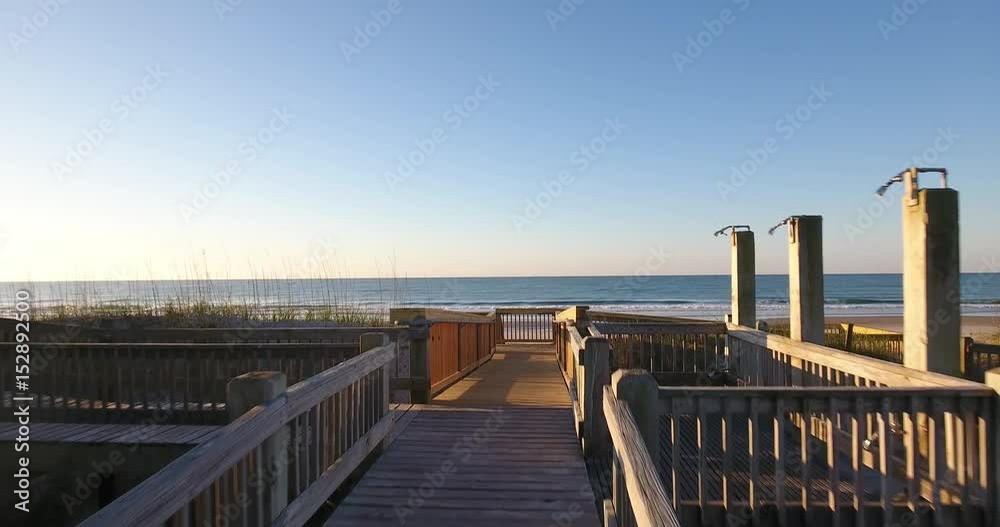 An aerial establishing shot approaching an empty beach.  	