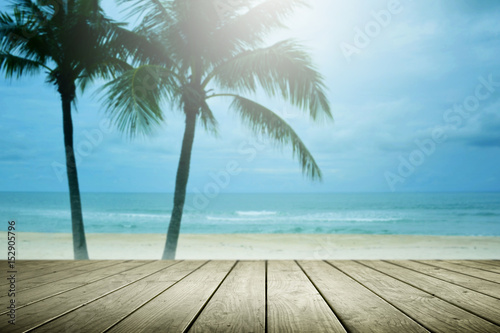 Blur beach background with palm tree and empty wooden.