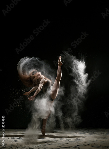 Sexy girl in a cloud of white dust studio portrait