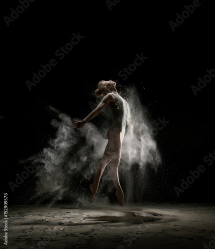 Sexy girl in a cloud of white dust studio portrait