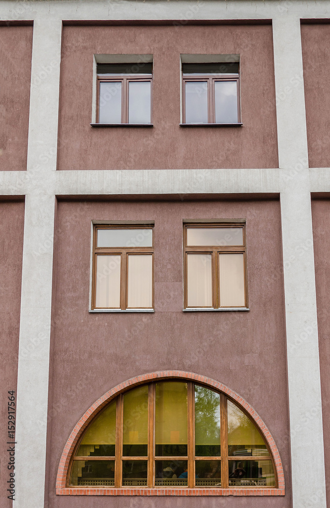Fototapeta premium Brown wall with arched window and columns