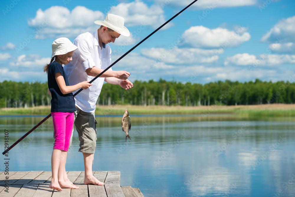 Dad and daughter caught a fish in a bait in the lake Dad and daughter caught a fish in a bait in the lake
