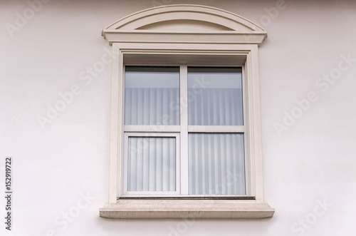 Beautiful window on white plaster wall