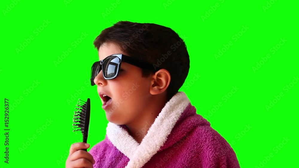 Portrait of a boy in a bathrobe, sunglasses and a comb on green screen Portrait of a boy in a bathrobe, sunglasses and a comb on green screen