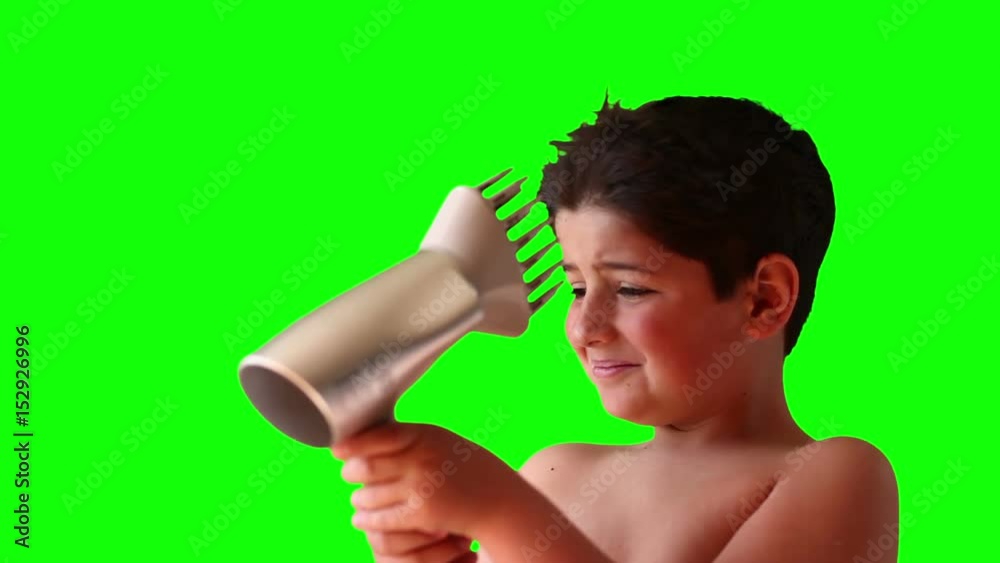 Boy blows hair with a hair dryer on a green screen Boy blows hair with a hair dryer on a green screen