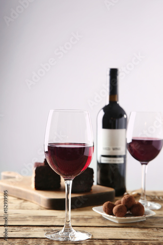 Red wine and delicious chocolate desserts on wooden table