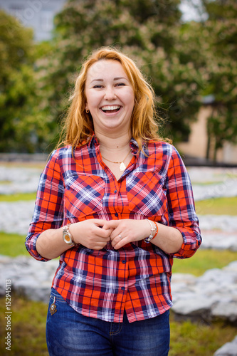Fotografie Simple american girl from next door in a plaid shirt walk in central park