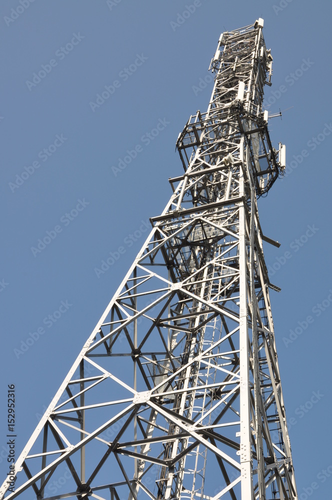 Telecommunication towers with antennas on clear blue sky