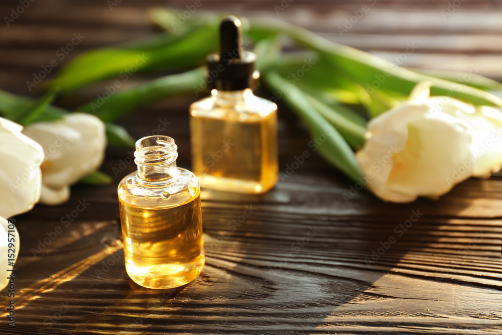 Composition with perfume and flowers on wooden table Composition with perfume and flowers on wooden table