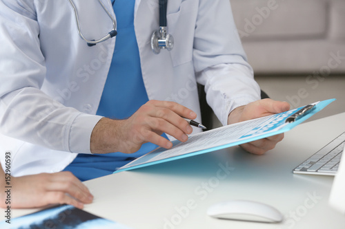 Hands of doctor with clipbo...