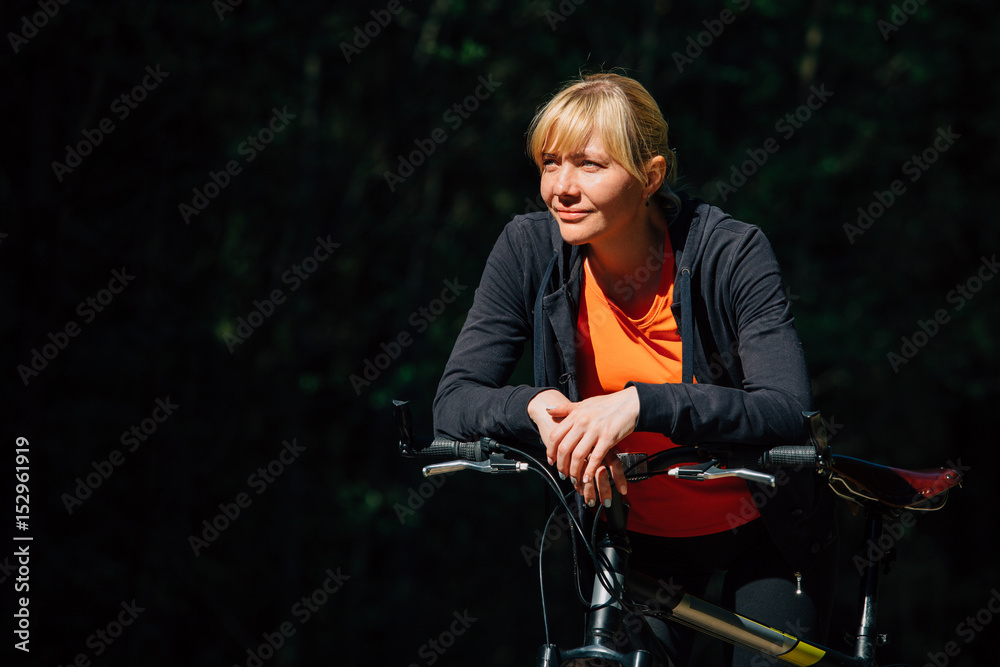 Young pretty woman having a rest after bicycle ride. Healthy lifestyle concept. Sports Girl with bike. Young pretty woman having a rest after bicycle ride. Healthy lifestyle concept. Sports Girl with bike.