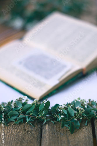 Lilac branches on a wooden background with a book. photo