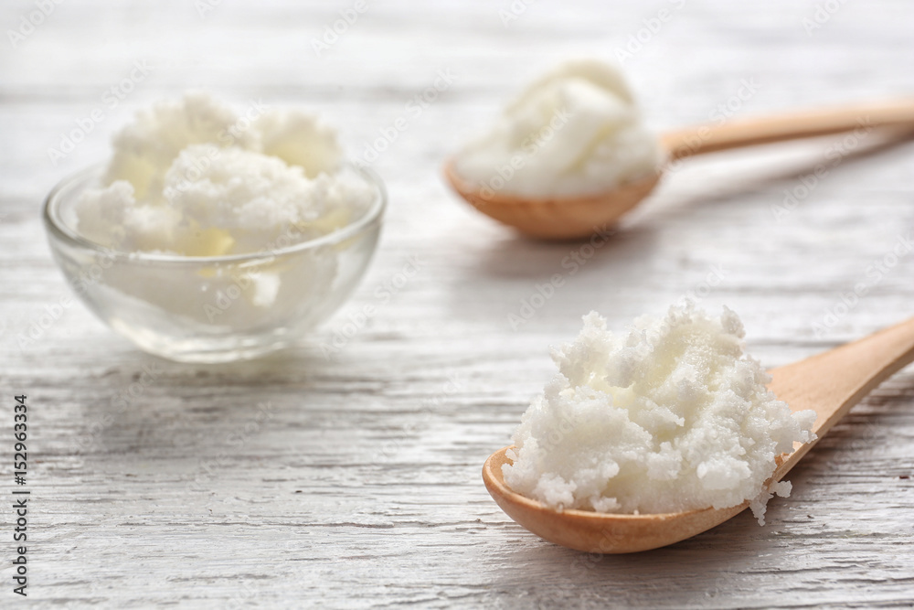Shea butter in spoons and bowl on wooden background, close up Shea butter in spoons and bowl on wooden background, close up