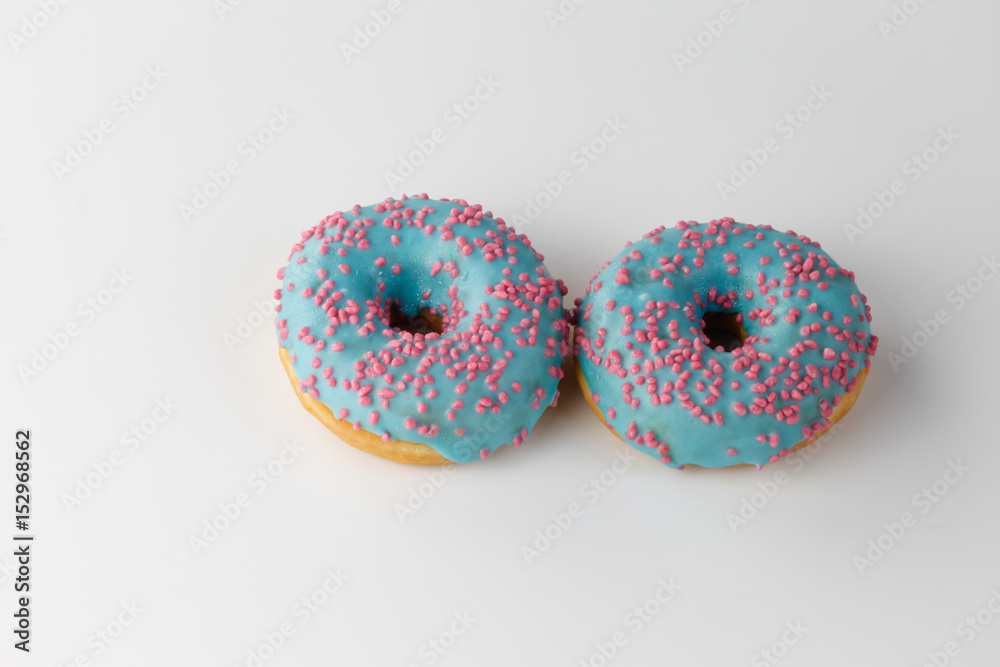 Donuts with blue glaze and pink sprinkles isolated on white background. Top view. Donuts with blue glaze and pink sprinkles isolated on white background. Top view.
