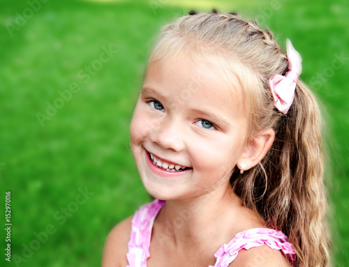 Portrait of adorable smiling little girl in the park