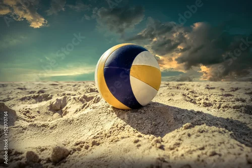 Obraz Siatkówka plażowa. Gemowa piłka pod światłem słonecznym i niebieskim niebem.