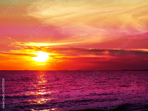 Sunset and cloud on horizon and purple water © darkfoxelixir
