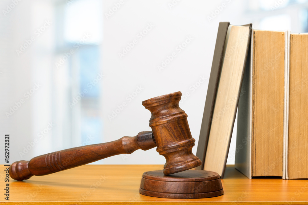 Wooden gavel and books on wooden table Wooden gavel and books on wooden table