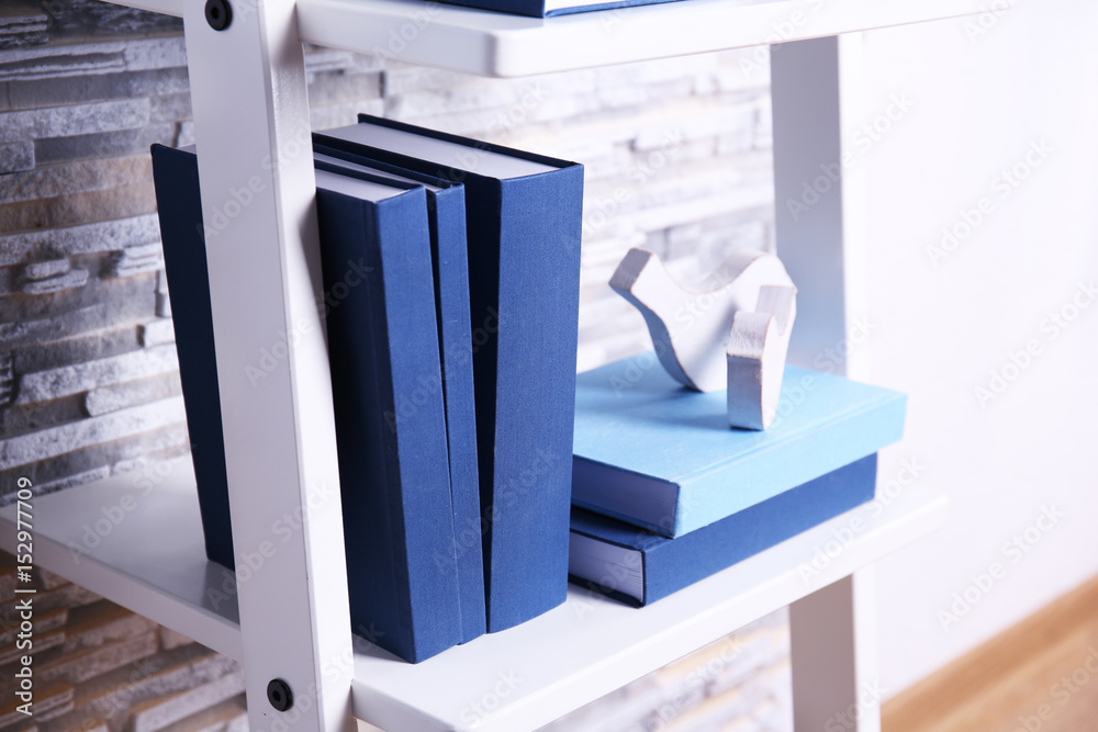 Books and decorations on white shelf at home Books and decorations on white shelf at home