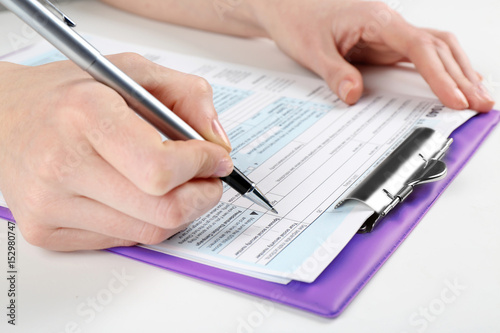 Woman filling form of Individual Income Tax Return, closeup