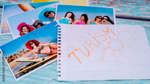 Photos of beautiful girls on the beach and a passport on a wooden table and a piece of paper with a canvas