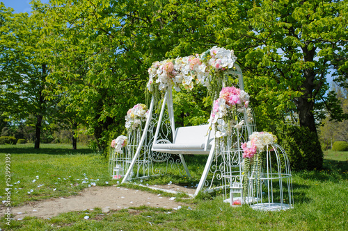 Wedding composition decoration in old vintage romantic style with white metal cages and nice swing