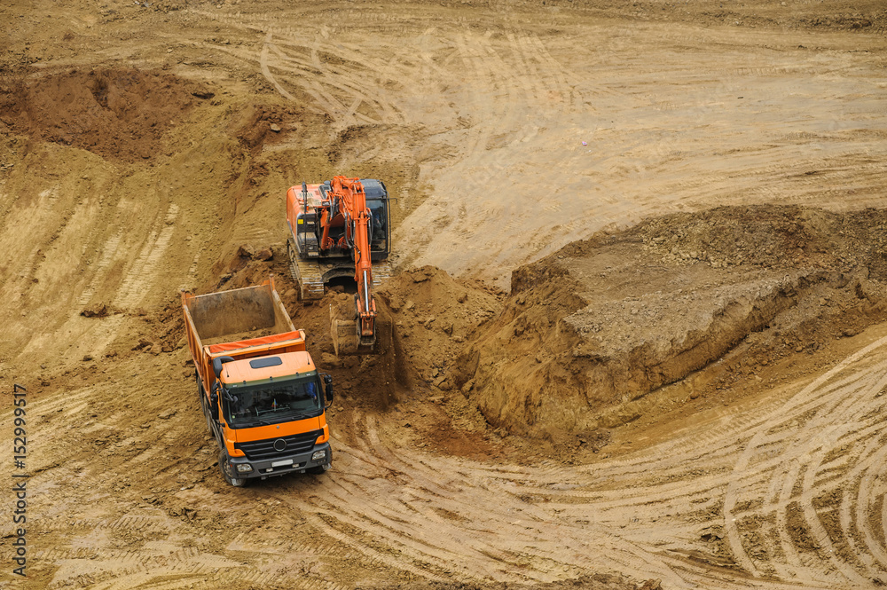 excavator moving earth and unloading into a dumper truck excavator moving earth and unloading into a dumper truck