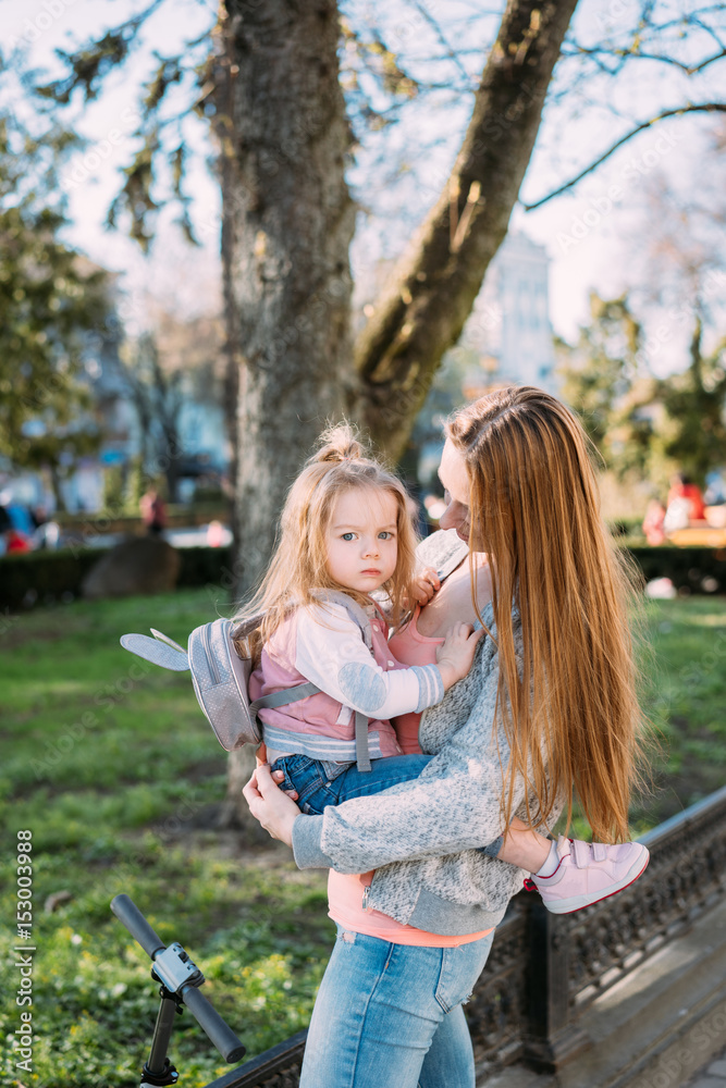 Mother holds a small daughter in her arms Mother holds a small daughter in her arms