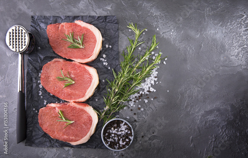 Meat for cooking steak, on a marble background.