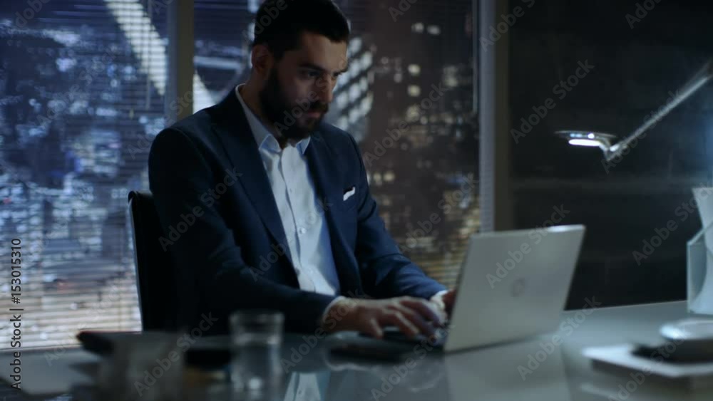Businessman Works on a Laptop in His Private Office with Big City Window View. Shot on RED EPIC-W 8K Helium Cinema Camera. Businessman Works on a Laptop in His Private Office with Big City Window View. Shot on RED EPIC-W 8K Helium Cinema Camera.
