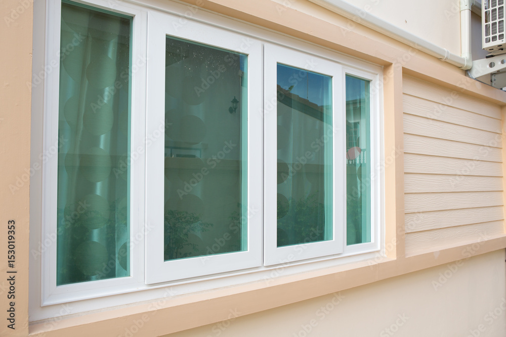 window with window blinds on wood walls.