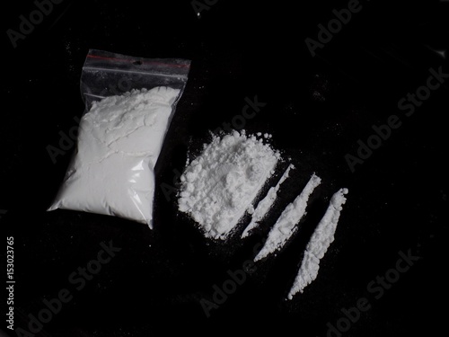 Cocaine drug powder bag, pile and lines on black background