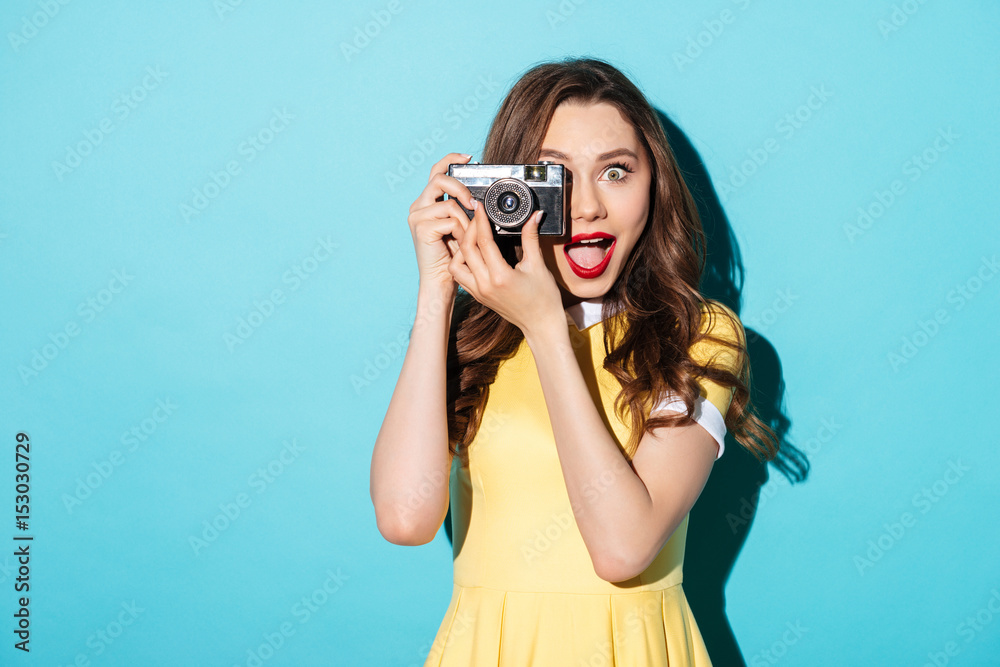 Portrait of a cheerful girl in dress using retro camera Portrait of a cheerful girl in dress using retro camera