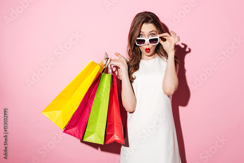 Shocked young brunette lady with shopping bags photo