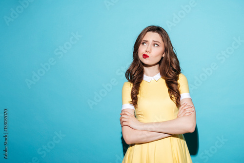 Portrait of a disappointed cute girl in dress standing
