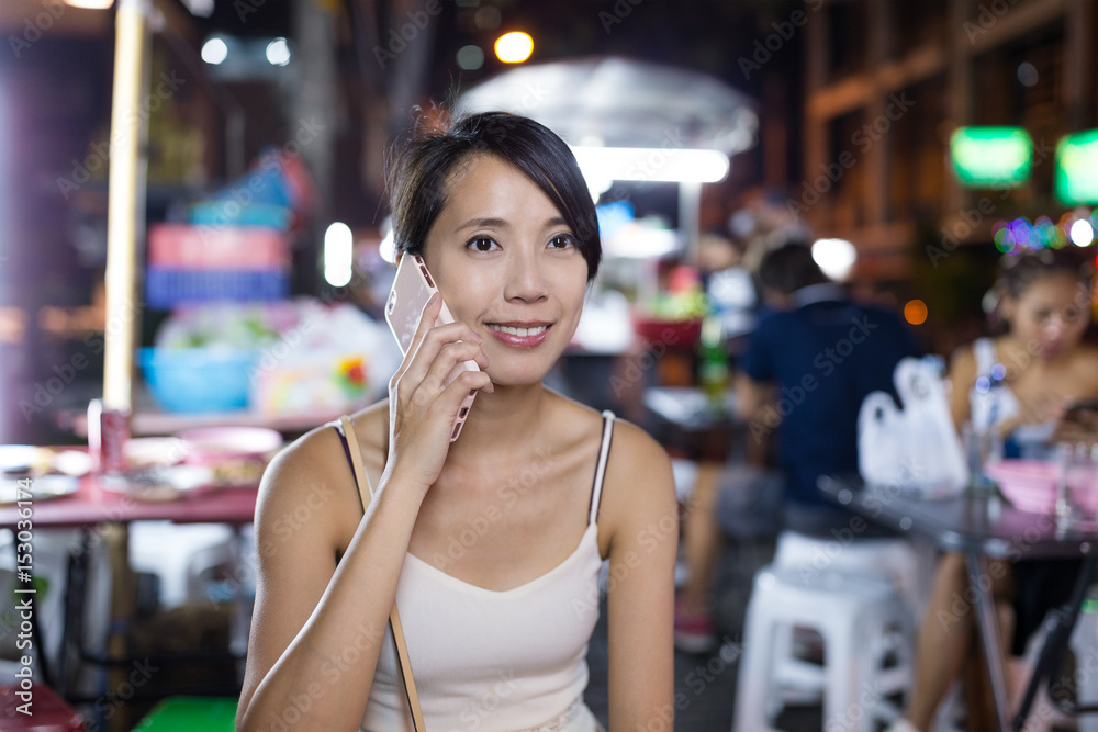 Woman using cellphone in night market
