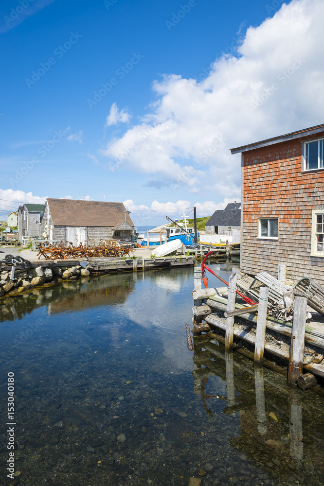 Scenic harborside view of the historic fishing village of Peggys Cove, on the maritime coast of Novia Scotia near Halifax, Canada, under bright blue sky