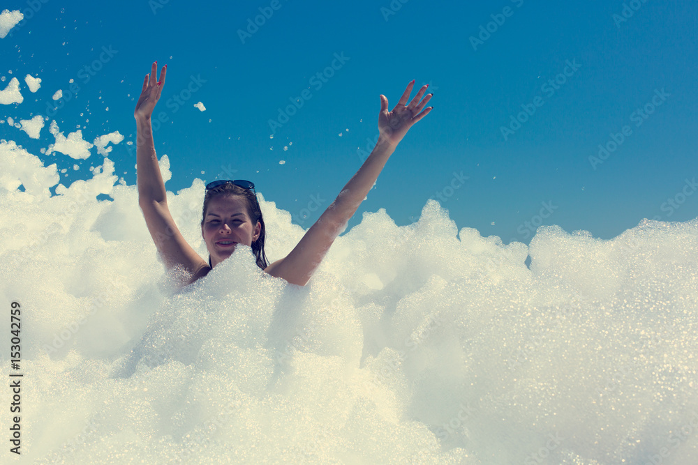 Happy young woman dancing on beach foam party Happy young woman dancing on beach foam party