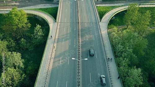 Aerial shot of cars and cyclists moving along highway in the evening
