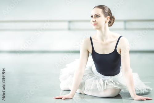 Bellerina sitting on the floor in ballet studio