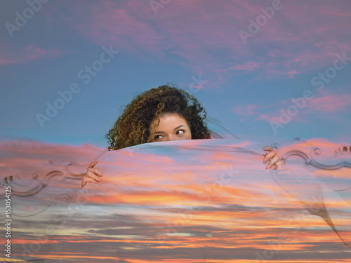 Картината върху платно Double exposure of woman with rascal look hiding behind colorful sunset