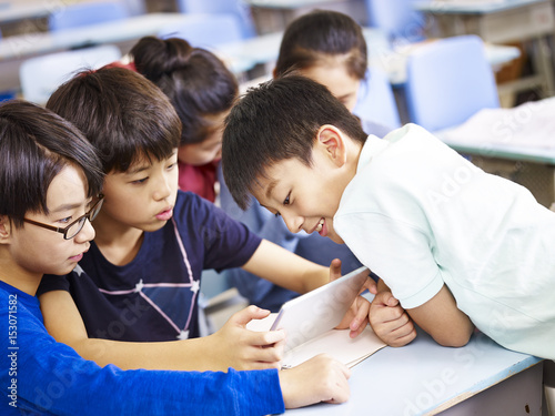 Wall Mural asian schoolchildren using digital tablet together
