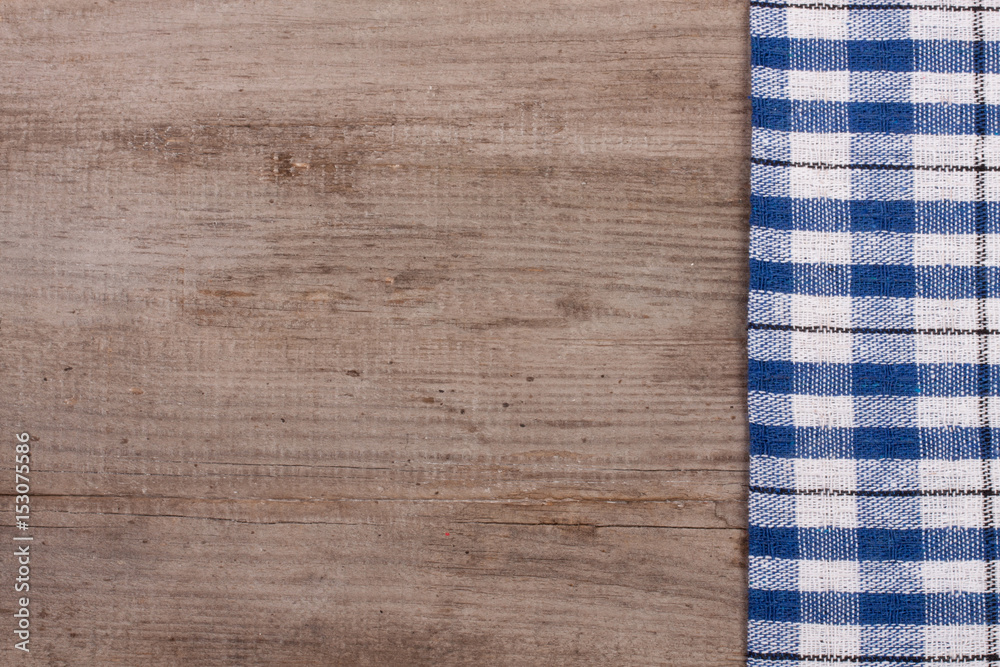 blue checkered tablecloth on an old wooden table with copy space for your text. Top view blue checkered tablecloth on an old wooden table with copy space for your text. Top view