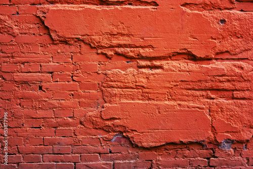 A wall of red brick  and a destroyed cement.