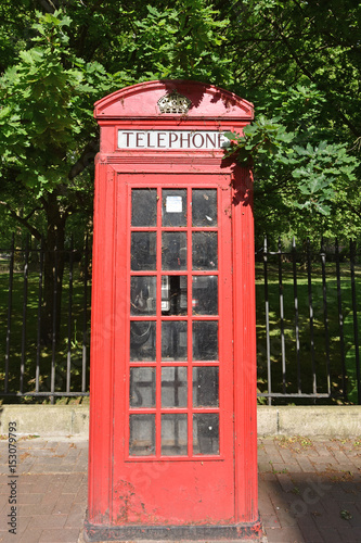 Old Red British Telephone Box on a sidewalk by Battersea Park.