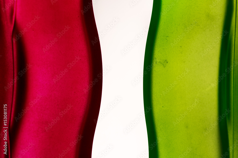 Curves in red and green glass surfaces, on white. Primary colors background Curves in red and green glass surfaces, on white. Primary colors background