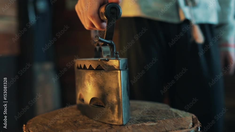 Unrecognisable man caucasian hand opens and close old style coal metal flatiron on three stump indoors cinematic light close up Unrecognisable man caucasian hand opens and close old style coal metal flatiron on three stump indoors cinematic light close up