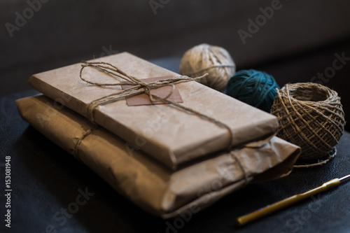 Knitted gift in parcel box wrapped in crumpled kraft paper