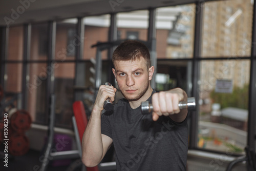 Man, boy, train in a sports club, warm up, boxing with dumbbells